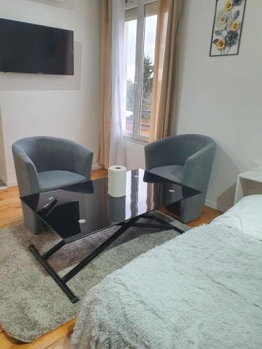 - une chambre avec deux chaises, un bureau et un lit dans l'établissement Studio pratique CDG/Villepinte/ le Bourget, à Aulnay-sous-Bois