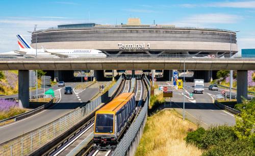 a train on the tracks in front of a building at Studio pratique CDG/Villepinte/ le Bourget in Aulnay-sous-Bois