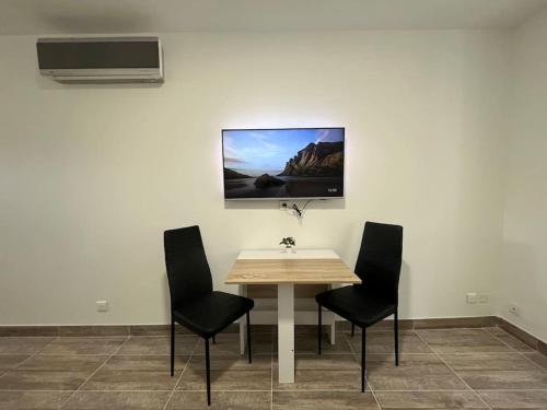 a table and chairs in a room with a picture on the wall at Superbe appartement à 15min de Lyon in Saint-Fons