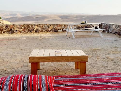 a table and bench in the middle of the desert at חלון למדבר in Arad