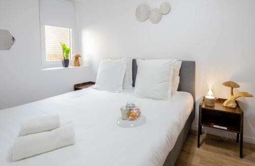 biała sypialnia z białym łóżkiem i stolikiem nocnym w obiekcie Cosmo ideal famille rue Carnot w Annecy