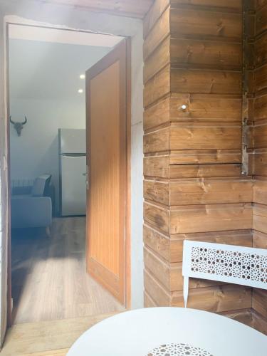 Cette chambre est dotée d'un mur en bois avec une porte et un banc. dans l'établissement Cosmo ideal famille rue Carnot, à Annecy