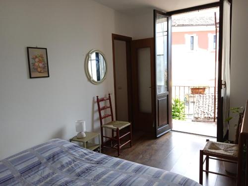 a bedroom with a bed and a door to a balcony at Appartamento Primo Sole in Primaluna