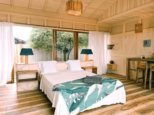 Schlafzimmer mit einem Bett, einem Schreibtisch und Fenstern in der Unterkunft Tribal Green Camp Private Room 1 in SantʼAna