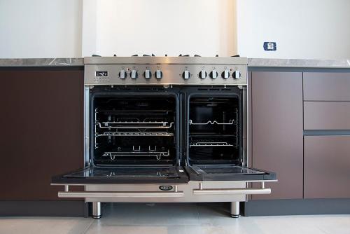 an oven with its doors open in a kitchen at Villa d'Anvers - Luxury Holiday Resort in Souda