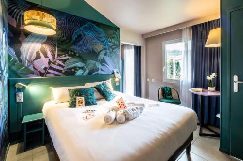a hotel room with a bed with playing cards on it at Hôtel Grand Confort Le Moulin Rouge in Terrasson-Lavilledieu