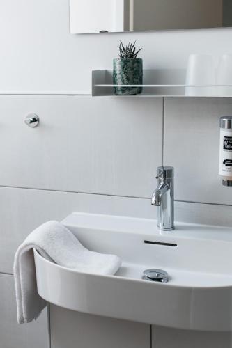 a white bathroom sink with a towel on it at Schlei Hotel in Kappeln
