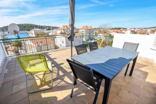 a balcony with a table and chairs on a roof at Apartments Ercegovic in Rogoznica
