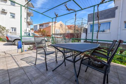 a table and chairs sitting on a patio at Apartments Ercegovic in Rogoznica