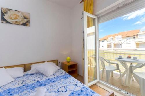 a bedroom with a bed and a balcony with a table at Apartments Anastazija in Vodice