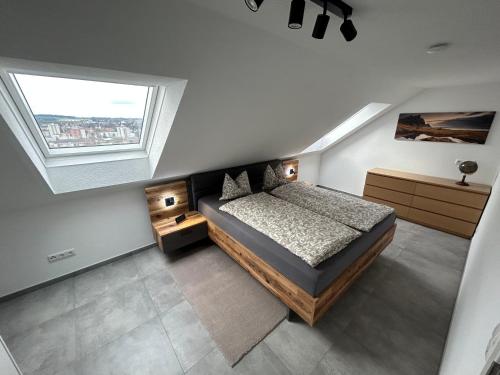an attic bedroom with a bed and a window at SO Apartment Steyr in Sankt Ulrich bei Steyr