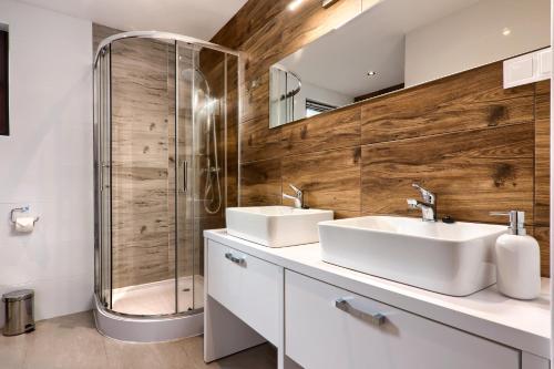 La salle de bains est pourvue de 2 lavabos et d'une douche. dans l'établissement Apartamenty Wierchówka, à Bukowina Tatrzańska