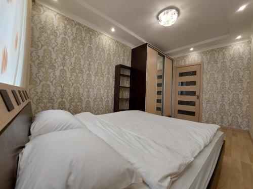 a bedroom with a large bed with white sheets at Набережна Двокімнатна in Luts'k