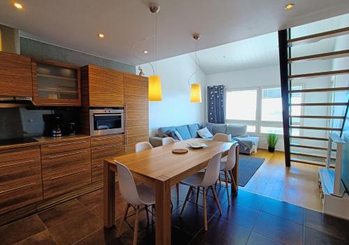 a kitchen and living room with a wooden table and chairs at The Peak House in Syöte