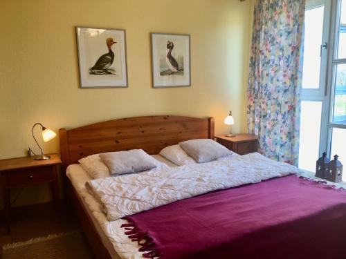 a bedroom with a large bed with a purple blanket at Ostseeresidenz - Whg 15 Ostseeblick in Zingst