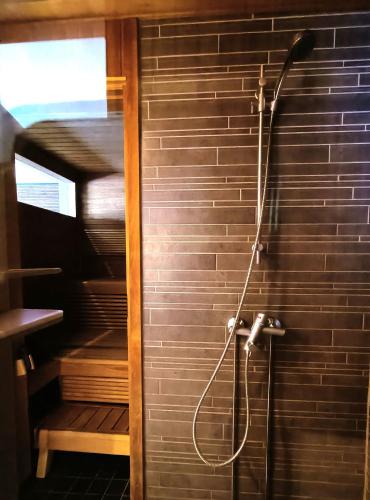 a shower with a hose attached to a brick wall at The Peak House in Syöte
