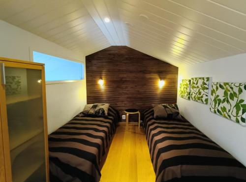 een kleine kamer met drie bedden in een kamer bij The Peak House in Syöte