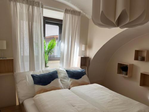een slaapkamer met een wit bed en een raam bij Stylische Gartenwohnung mit Bergblick in Sankt Michael ob Bleiburg