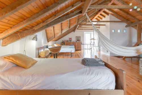 sypialnia z 2 łóżkami i hamakiem w obiekcie Casa da Foz - Charming House w mieście Foz do Arelho