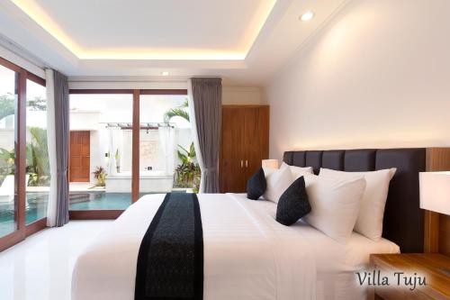 a bedroom with a large bed and a pool at Villa Mia Seminyak - Boutique Villas in Seminyak