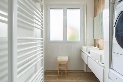 een witte badkamer met een wastafel en een raam bij "Le Marmuzot" - Confort - Calme - Parking Free in Dijon