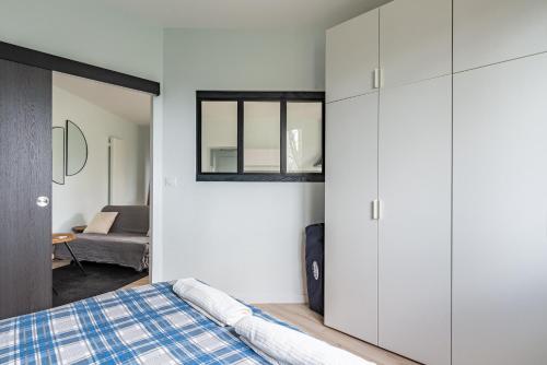 een slaapkamer met witte kasten en een bed bij "Le Marmuzot" - Confort - Calme - Parking Free in Dijon