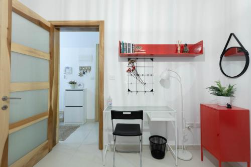 Habitación con escritorio con silla y armario rojo. en Namaste :) Enjoy Every Moment, en Mellieħa