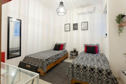 a bedroom with two beds and a mirror at Namaste :) Enjoy Every Moment in Mellieħa
