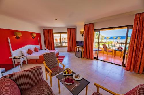 a hotel room with a bed and a living room at Flamenco Beach & Resort Quseir in Quseir