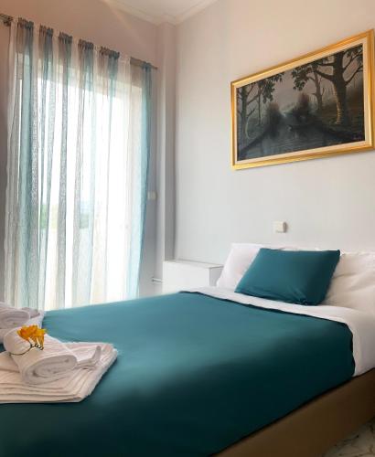 a bedroom with a blue bed with a painting on the wall at Vintage Manor in Anavyssos