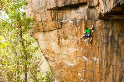 a man is climbing on a rock wall at Black Ridgetop at NRG National Park in Lansing