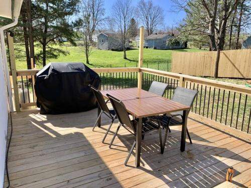 a wooden deck with a table and chairs on it at Black Ridgetop at NRG National Park in Lansing