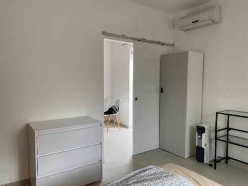 ein weißes Schlafzimmer mit einem Schrank und einer Kommode in der Unterkunft Apartment Olive in Medulin