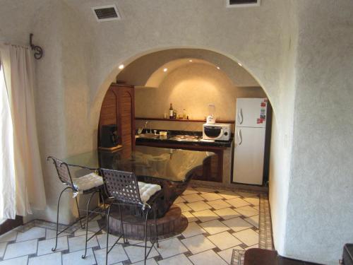 a kitchen with an archway with a counter and a refrigerator at Beautiful apartment fully restored after OTIS in Acapulco Diamante in Acapulco