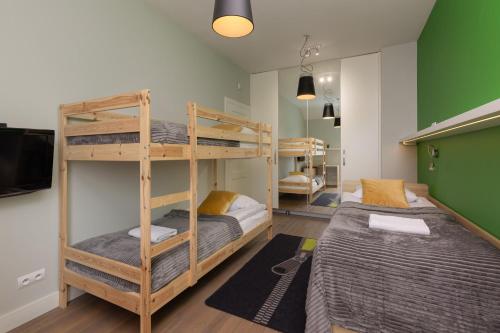 a room with two bunk beds and a tv at Three-Bedroom Family House with Garden Warsaw Nowa Wieś by Noclegi Renters in Warszawa