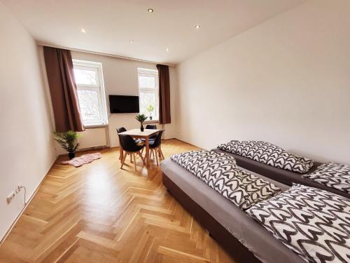 1 dormitorio con 1 cama y 1 mesa con sillas en Donaufelder City Apartment en Viena