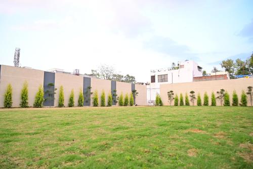 a building with a grass field in front of it at Ramada Encore by Wyndham Bareilly Civil Lines in Bareilly