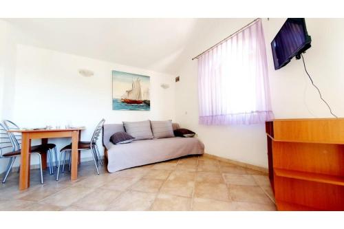 ein Wohnzimmer mit einem Sofa und einem Tisch in der Unterkunft Apartments Villa Višnja in Pašman