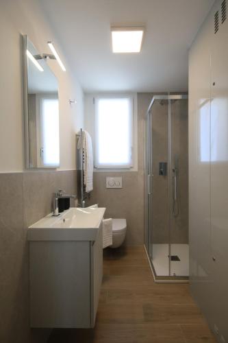 uma casa de banho com um lavatório e um chuveiro em Blu Homes Apartments EfStyle Hotel em Lido di Jesolo