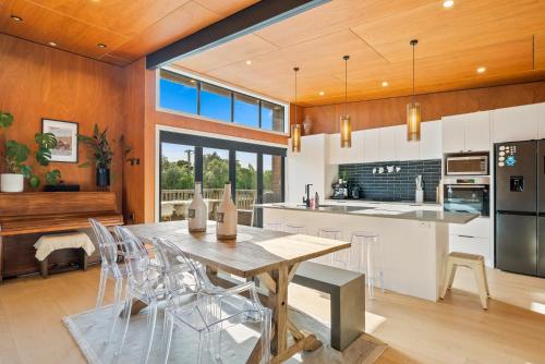 a kitchen and dining room with a table and chairs at Beachside Sanctuary - Otaki Beach Holiday Home in Otaki Beach
