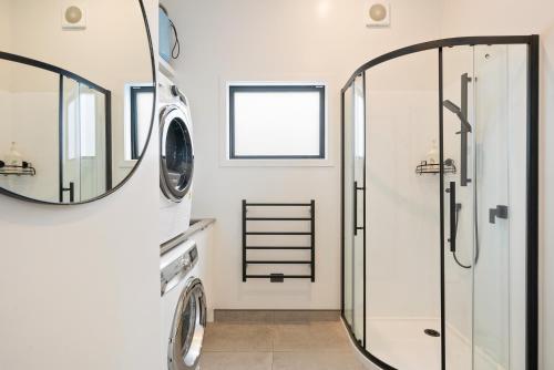 a bathroom with a shower and a mirror at Beachside Sanctuary - Otaki Beach Holiday Home in Otaki Beach