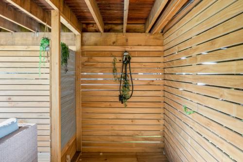 a sauna with a wooden wall at Beachside Sanctuary - Otaki Beach Holiday Home in Otaki Beach