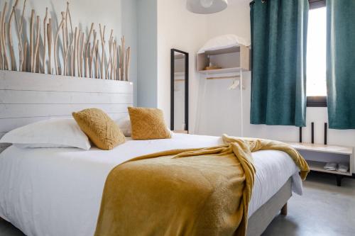 Un dormitorio con una cama con una manta amarilla. en D'OR Les Anges en Les Angles Gard