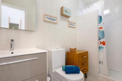 ein weißes Badezimmer mit Toilette und Waschbecken in der Unterkunft Beach Apartment Corralejo Escape in Corralejo