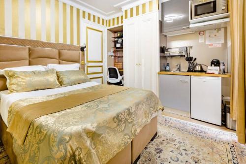 a bedroom with a large bed and a kitchen at Premium studio 2 minutes walk from Champs-Elysees in Paris