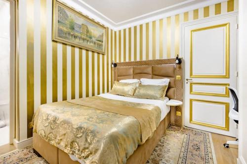 - une chambre avec un lit aux murs rayés jaunes dans l'établissement Premium studio 2 minutes walk from Champs-Elysees, à Paris