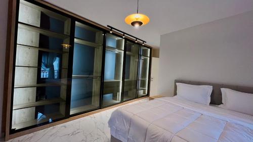 sypialnia z łóżkiem i dużym oknem w obiekcie Zeus Tirana Suite Deluxe w Tiranie