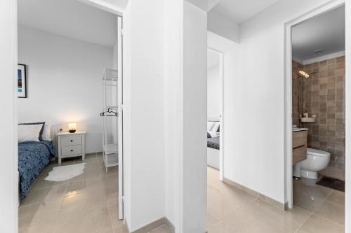 Un dormitorio blanco con una cama y un espejo. en Home2Book Charming Apartment Teguise, Terrace, en Teguise