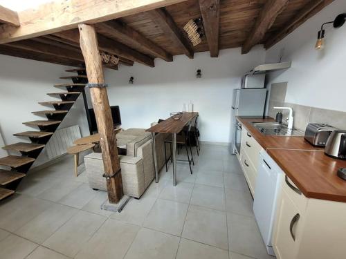 une cuisine avec une table et un escalier en colimaçon dans l'établissement Gîte La Toue, à Saint-Dyé-sur-Loire