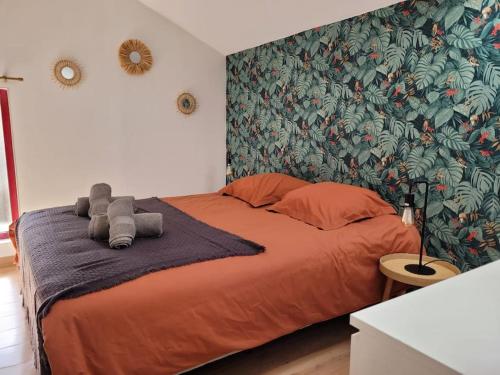 - une chambre avec un grand lit orange et un papier peint tropical dans l'établissement Gîte La Toue, à Saint-Dyé-sur-Loire